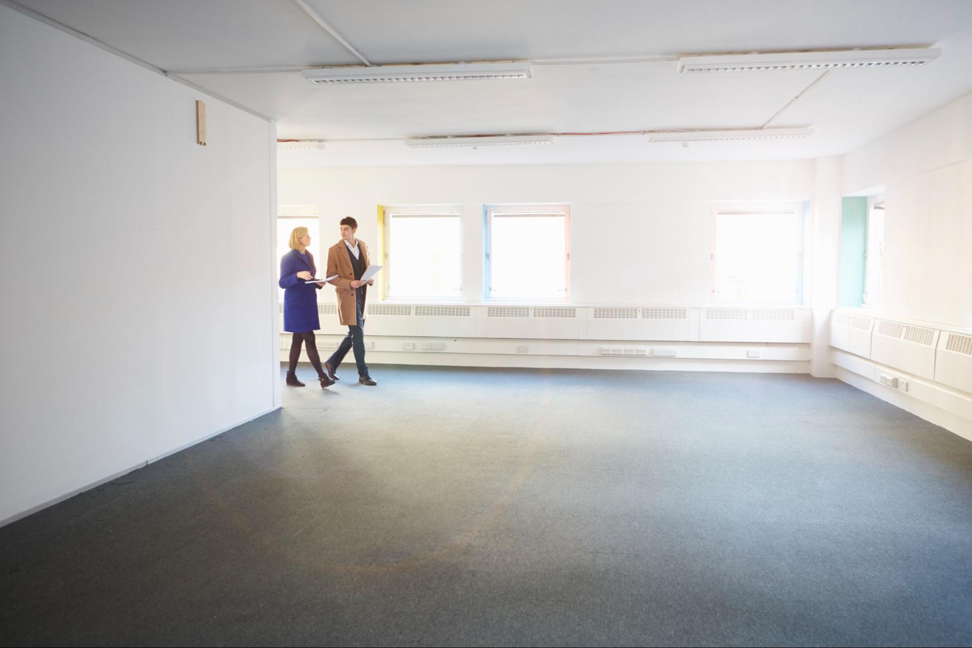 Property managers walking through vacant area of commercial property
