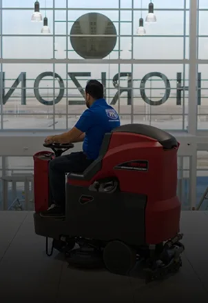 Picture Perfect Cleaning team member operating a ride-on floor scrubber